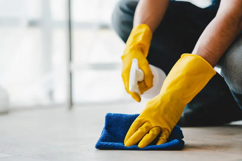 Gloved hand wiping down a home surface during a recurring house cleaning